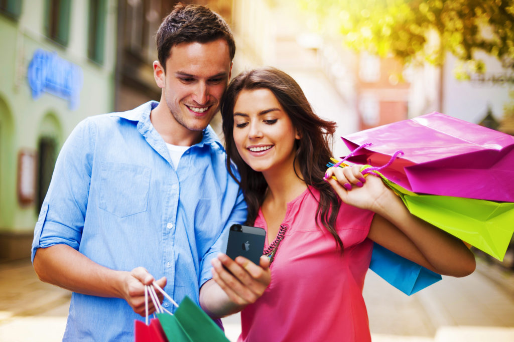 femme et homme en séance shopping regardant un téléphone